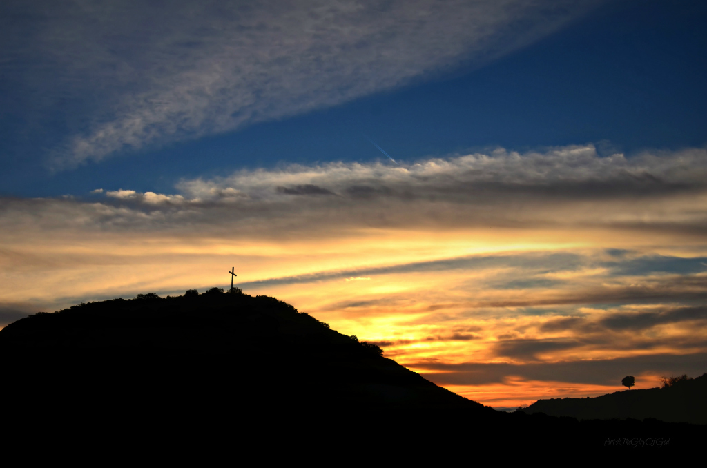cross on hill with sunset