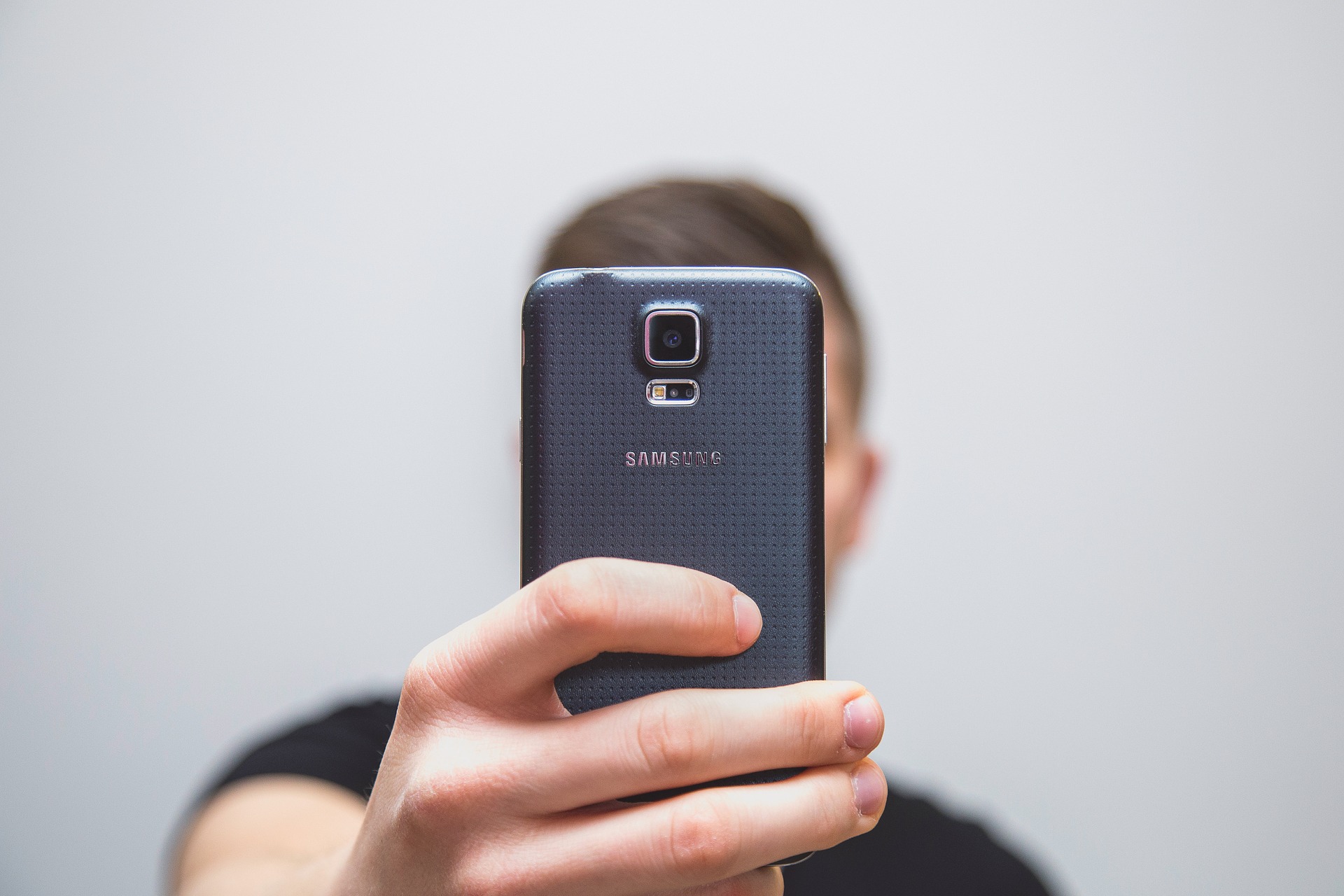 Man holding a phone in front of his face to take a selfie